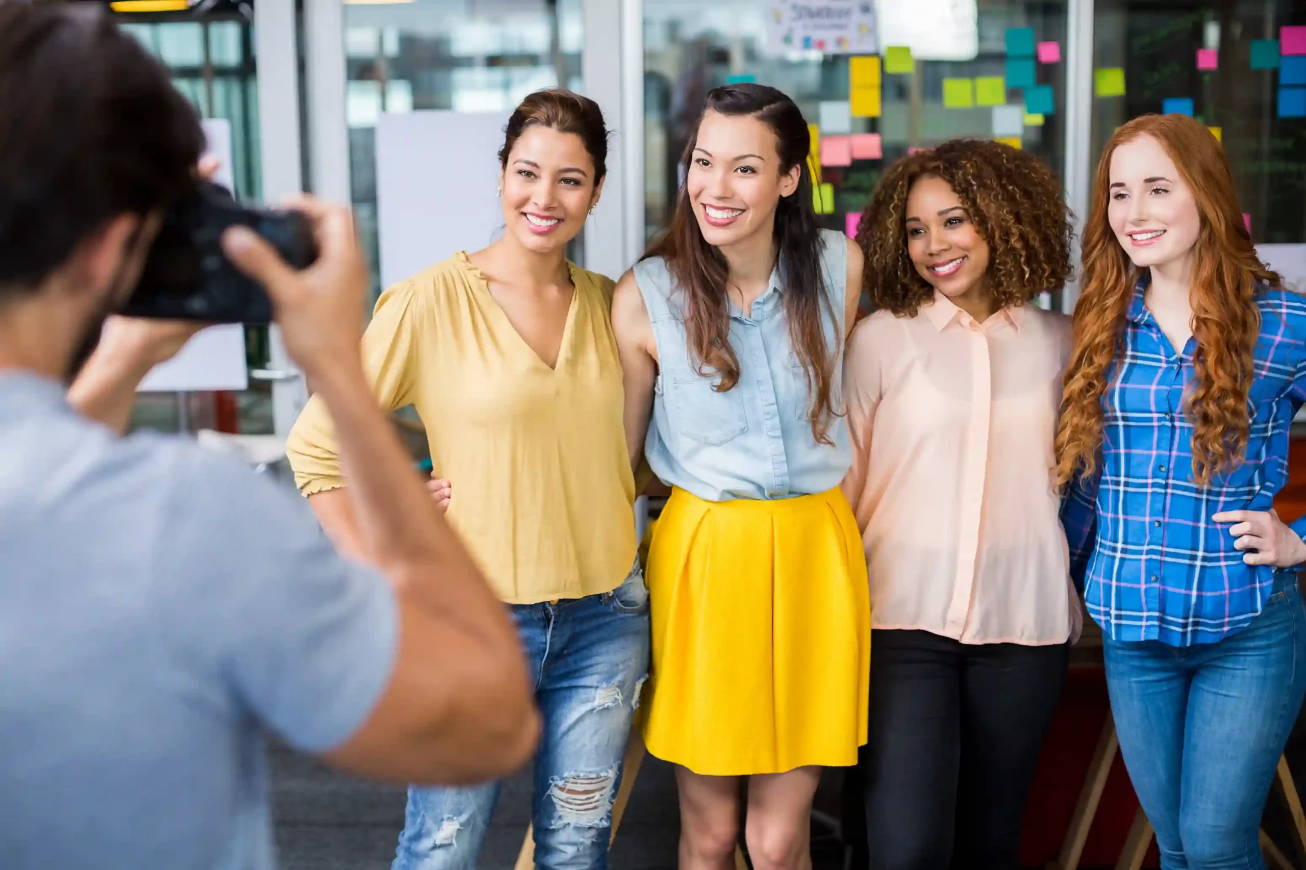 Photographe événementiel – Souvenirs et cohésion d’équipe Photographe prenant en photo une équipe de femmes lors d’un événement d’entreprise